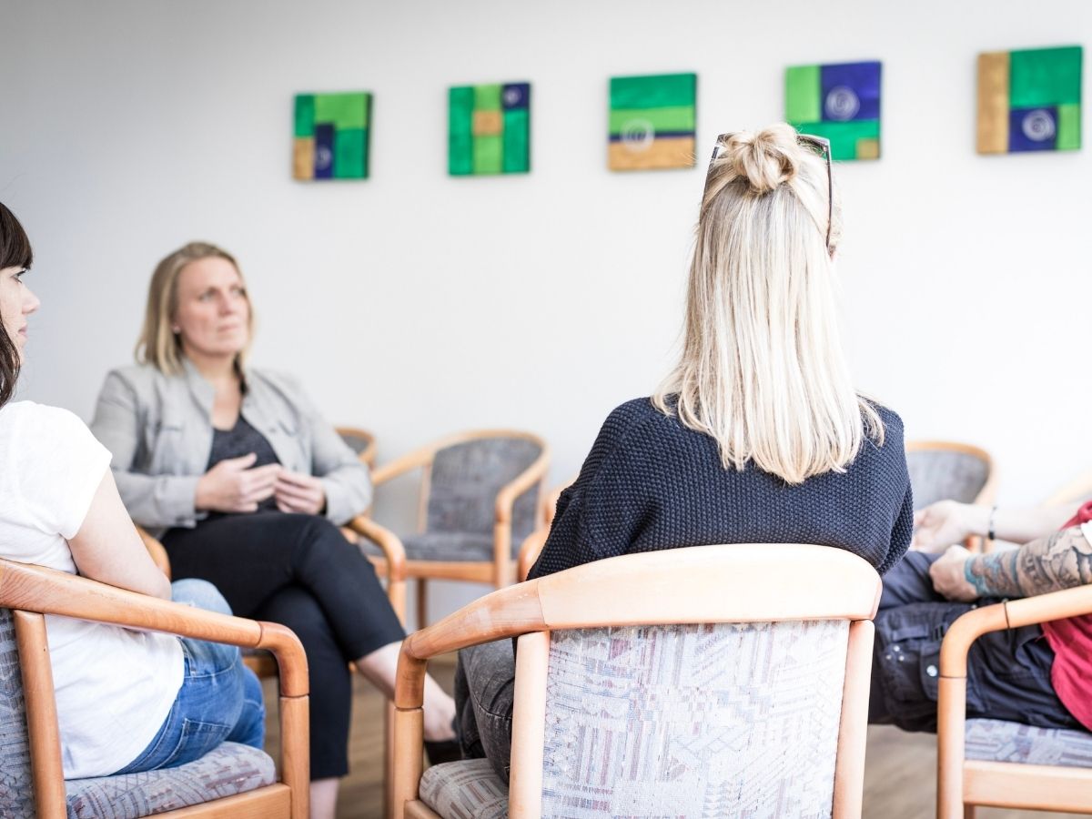 Personen die zusammen in einem Stuhlkreis sitzen 