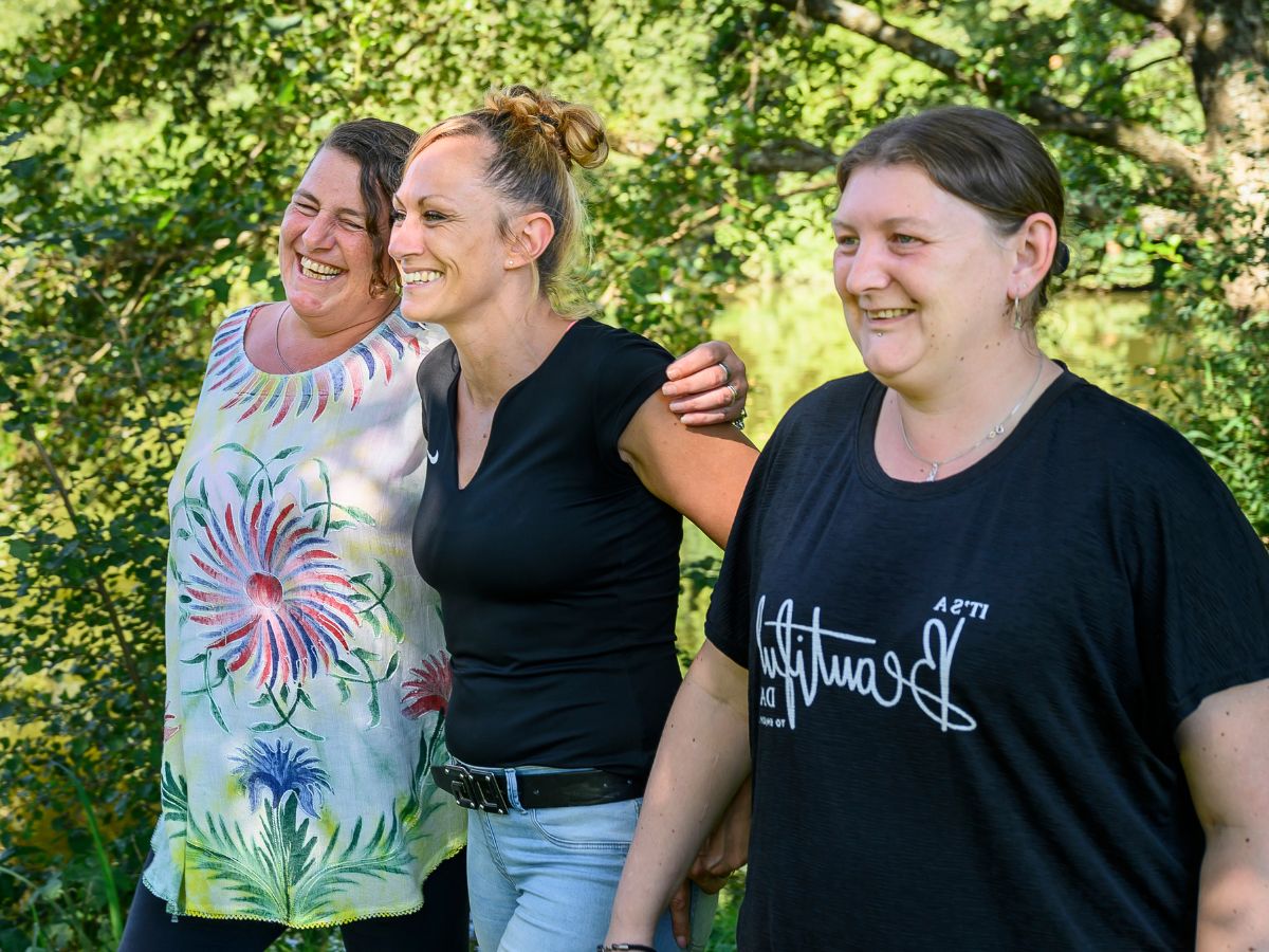 Drei Personen sind draußen und hören jemandem zu 