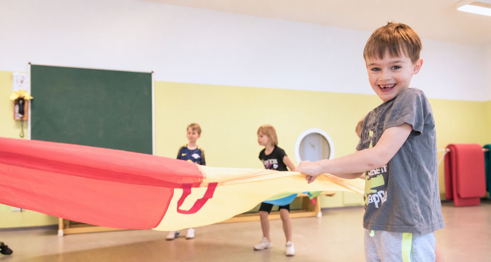 Kinder die ein Schwungtuch in der Hand halten 