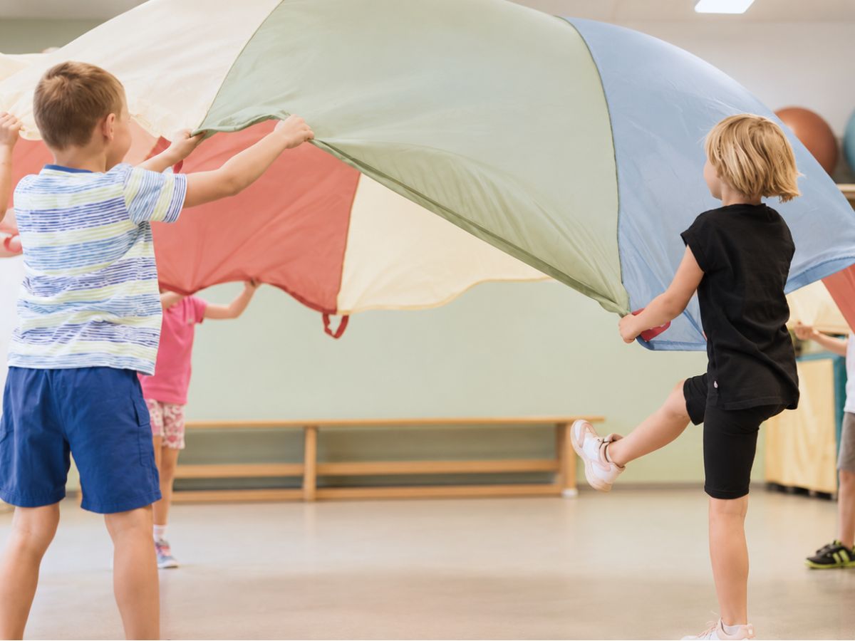 Kinder die mit einem Schwungtuch spielen 