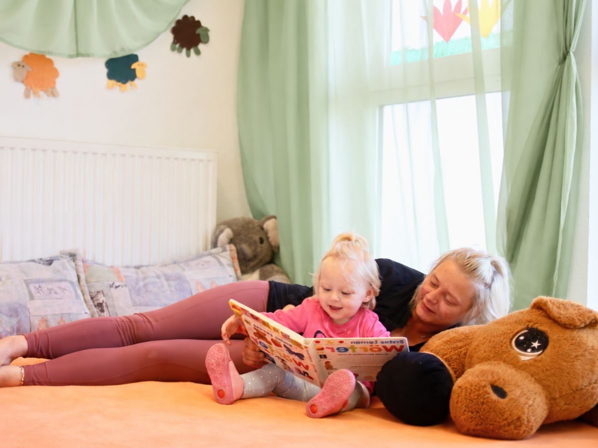 Eine Mama die mit ihrem Kind zusammen liest 