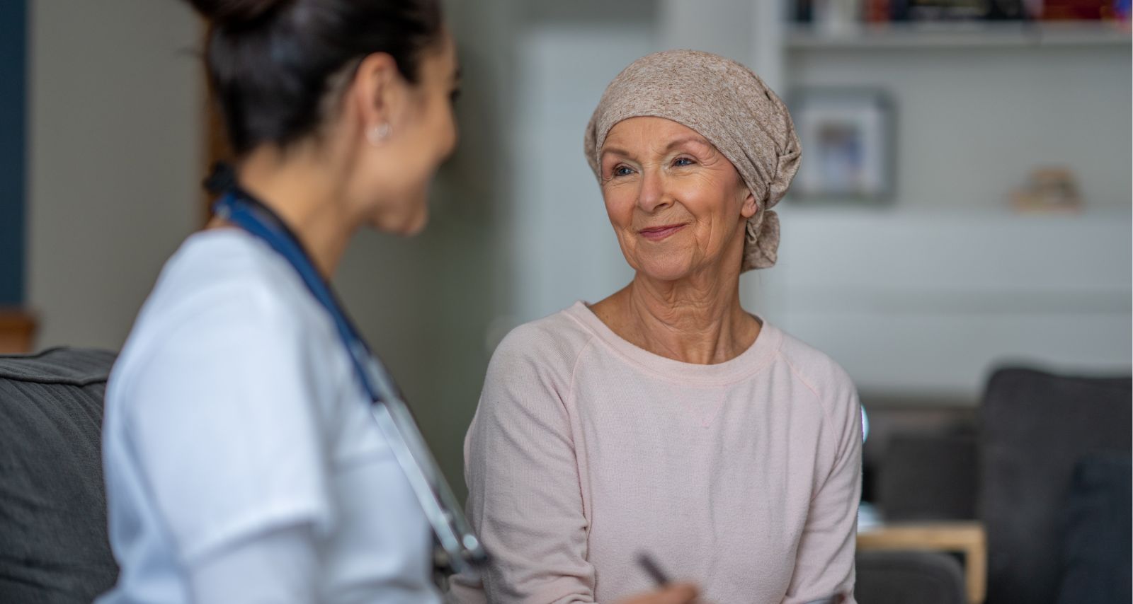 Die Ärztin und die Patientin lächeln sich an 