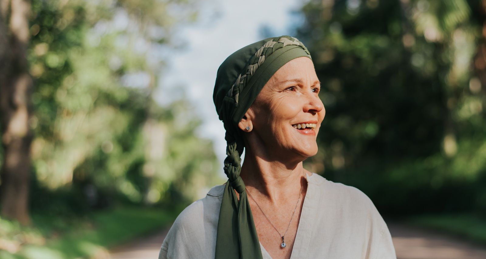 Eine Frau die draußen spazieren geht und lächelt 