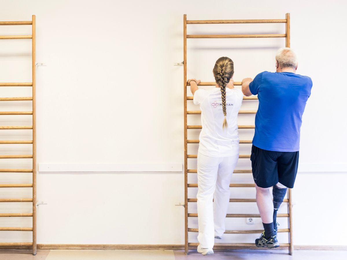 Zwei Personen die an einer Sprossenwand Übungen machen 