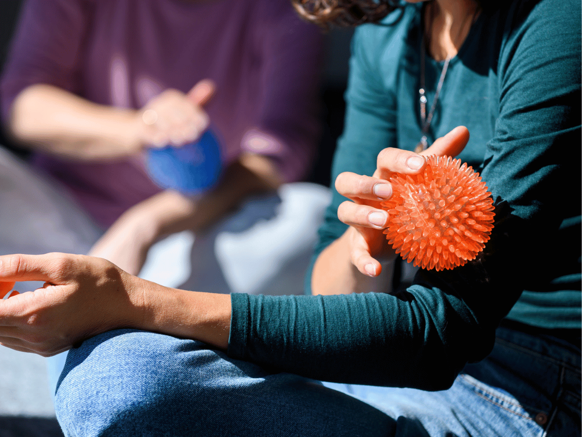 Personen die sich mit einem Massageball über den Arm gehen 