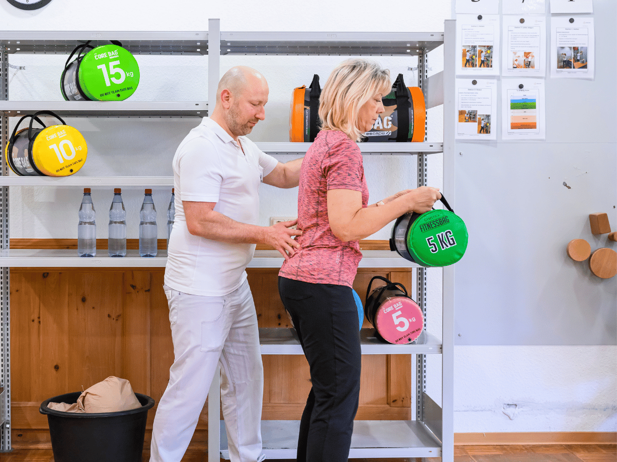 Der Pfleger hilft der Patientin bei der Übung 