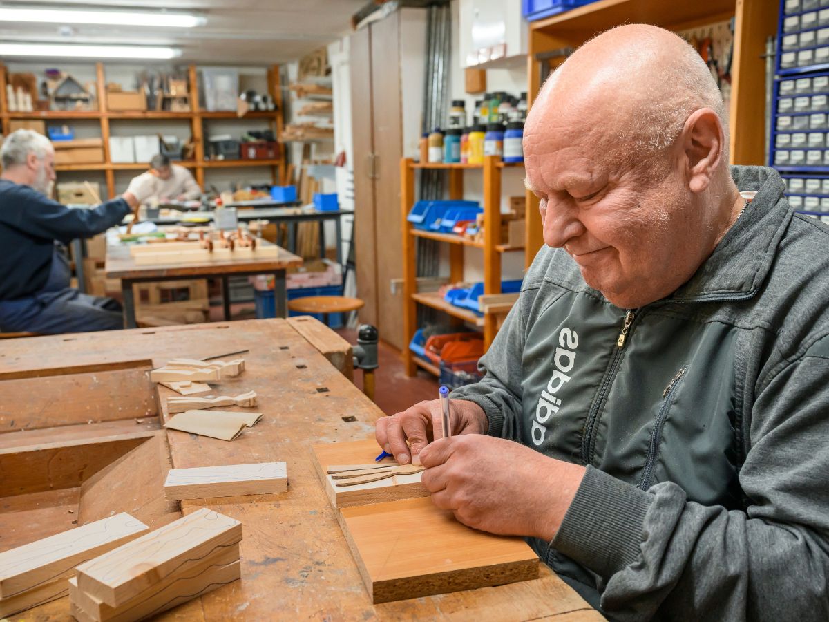 Ein Mann der etwas in der Werkstatt baut