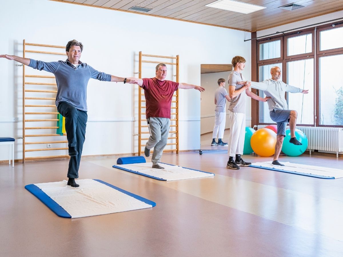 Eine Gruppe die auf Matten Sport machen 