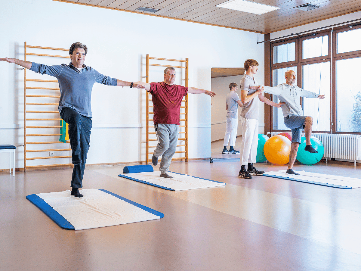 Eine Gruppe die auf Matten Sport machen 