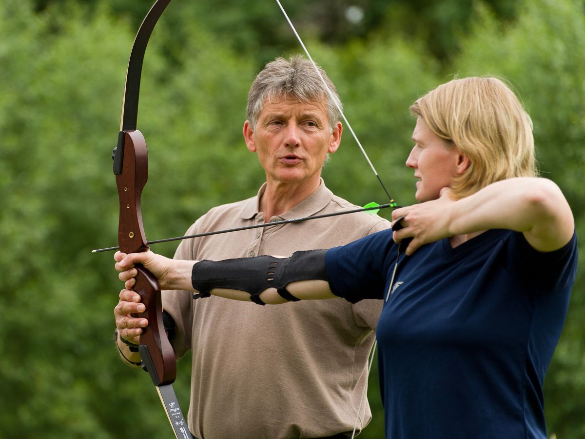 Die Frau hat einen Pfeil und Bogen in der Hand 