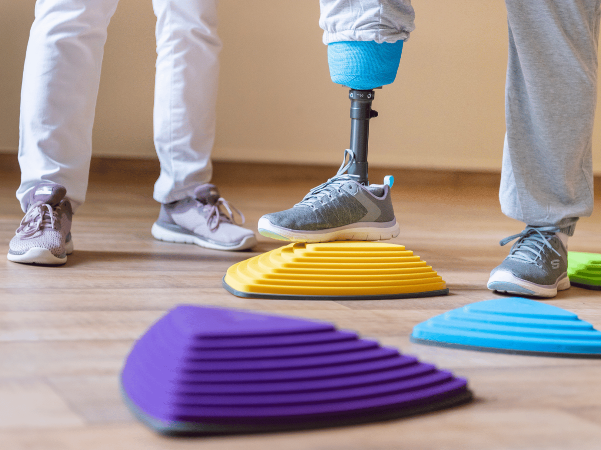 Eine Person die mit einer Prothese auf einen Gegenstand steht 