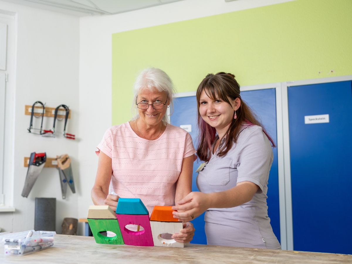 Die Schwester zeigt der Patientin Gegenstände 