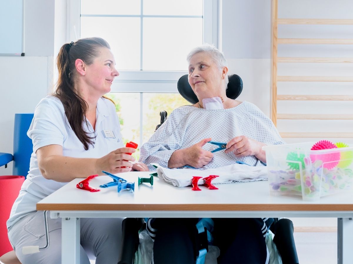 Die Frau führt eine Übung durch im Rahmen einer Ergotherapie aufgrund ihres Therapieablaufs und Klinikalltag 