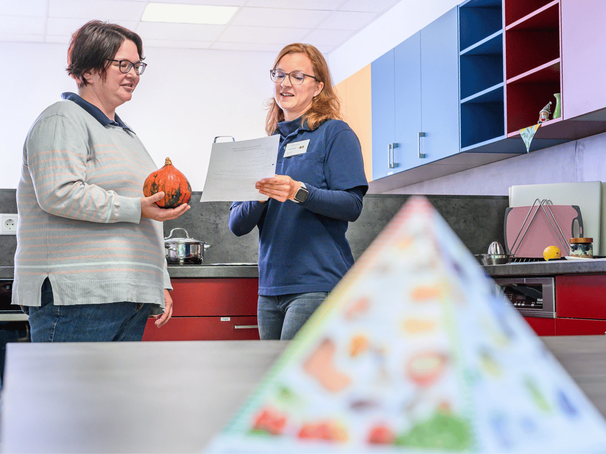 Zwei Frauen die sich unterhalten und vor ihnen steht eine Pyramide 