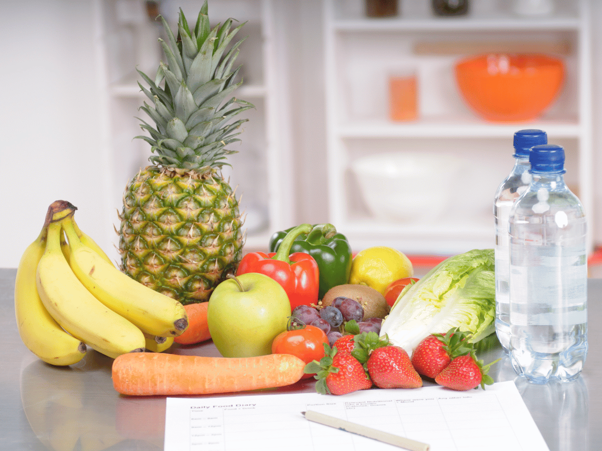 Auf einem Tisch liegt Obst, Gemüse und Wasser 