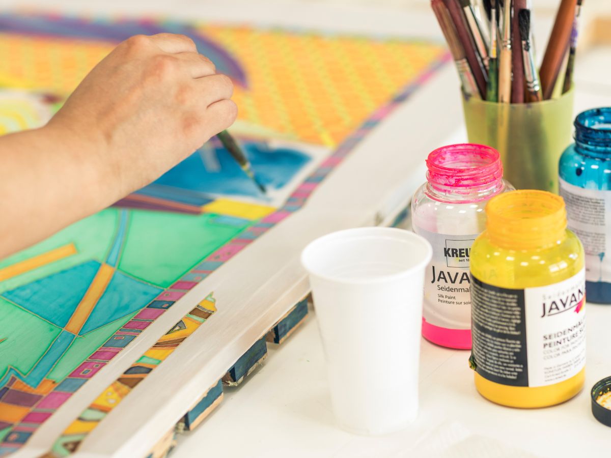 Eine Person malt ein Bild mit bunten Farben