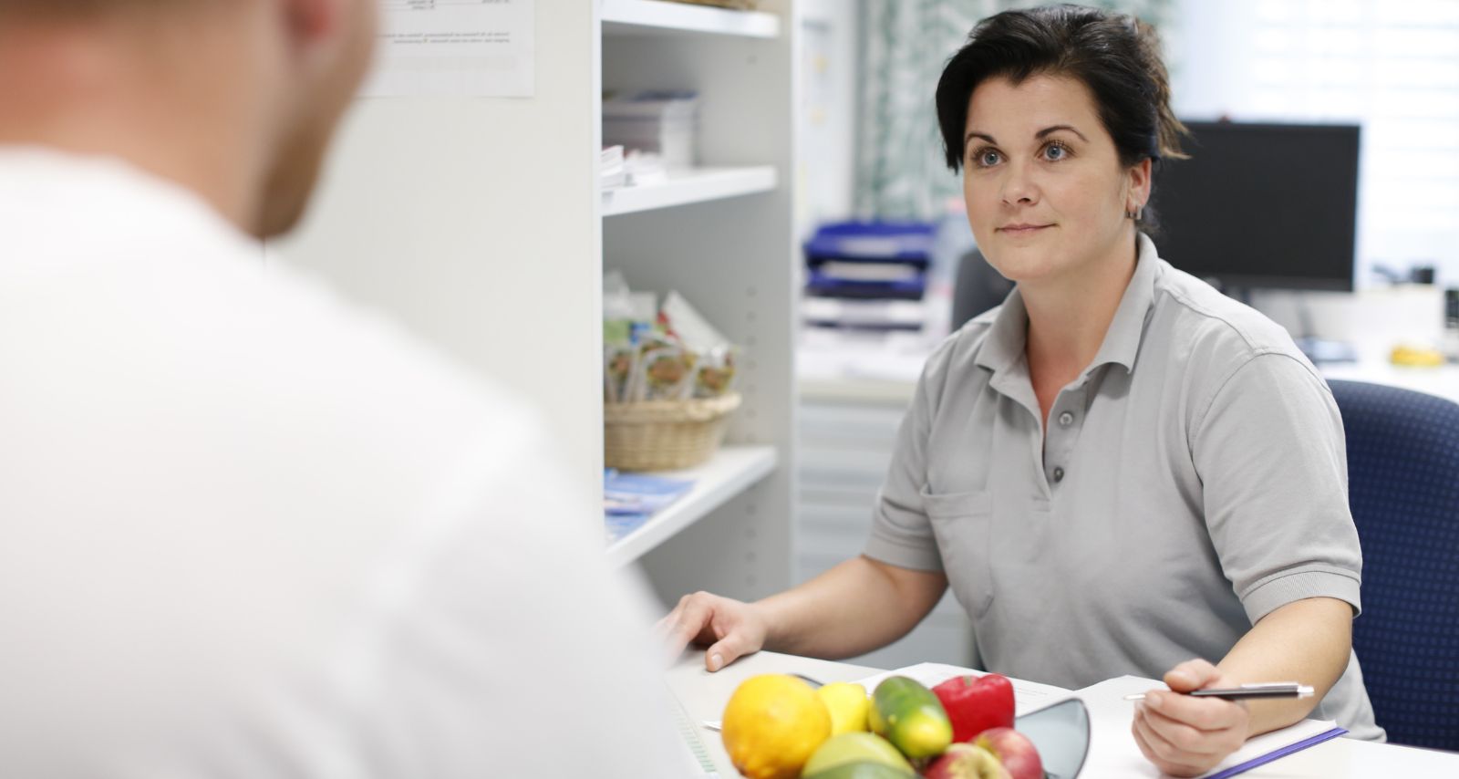 Eine Frau redet mit einer Person und vor ihr liegt Essen 