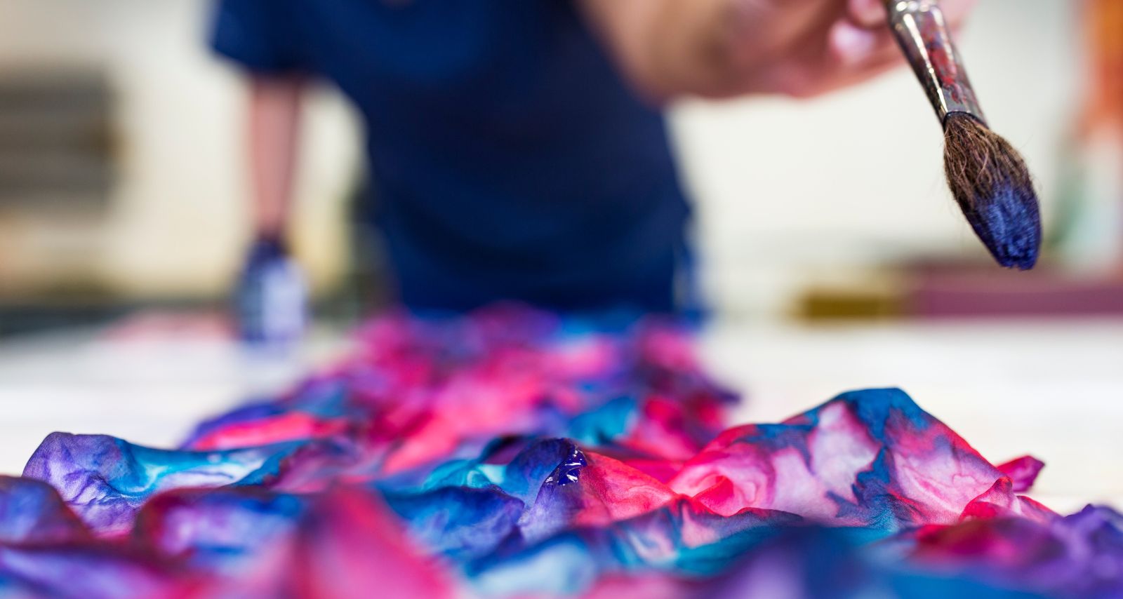 Eine Person hat einen Pinsel in der Hand und malt