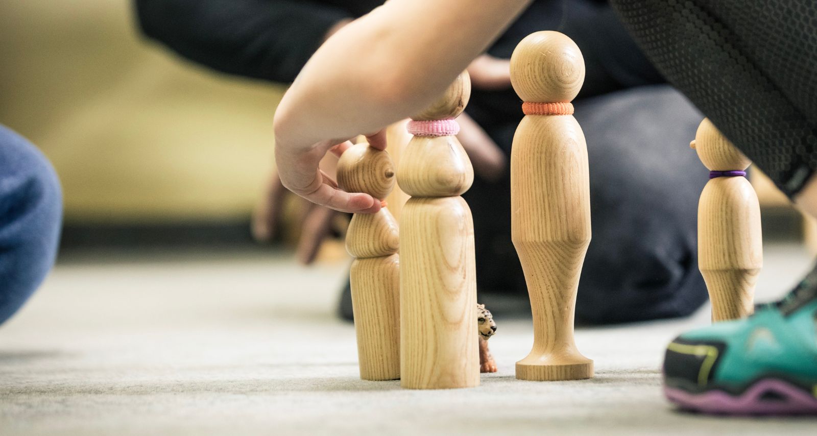Eine Person stellt Holzfiguren auf 