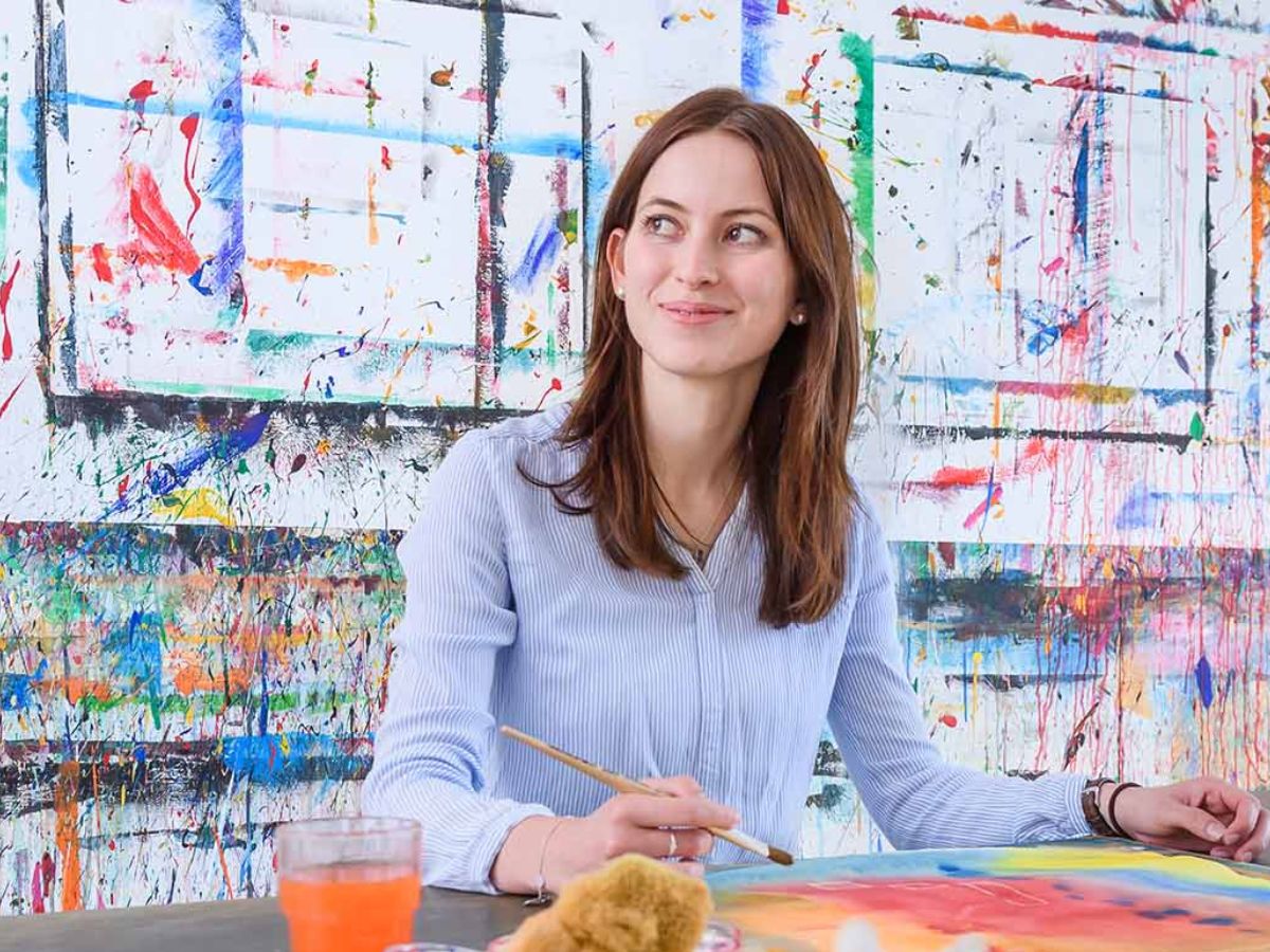 Eine Frau malt auf ein Blatt Papier 