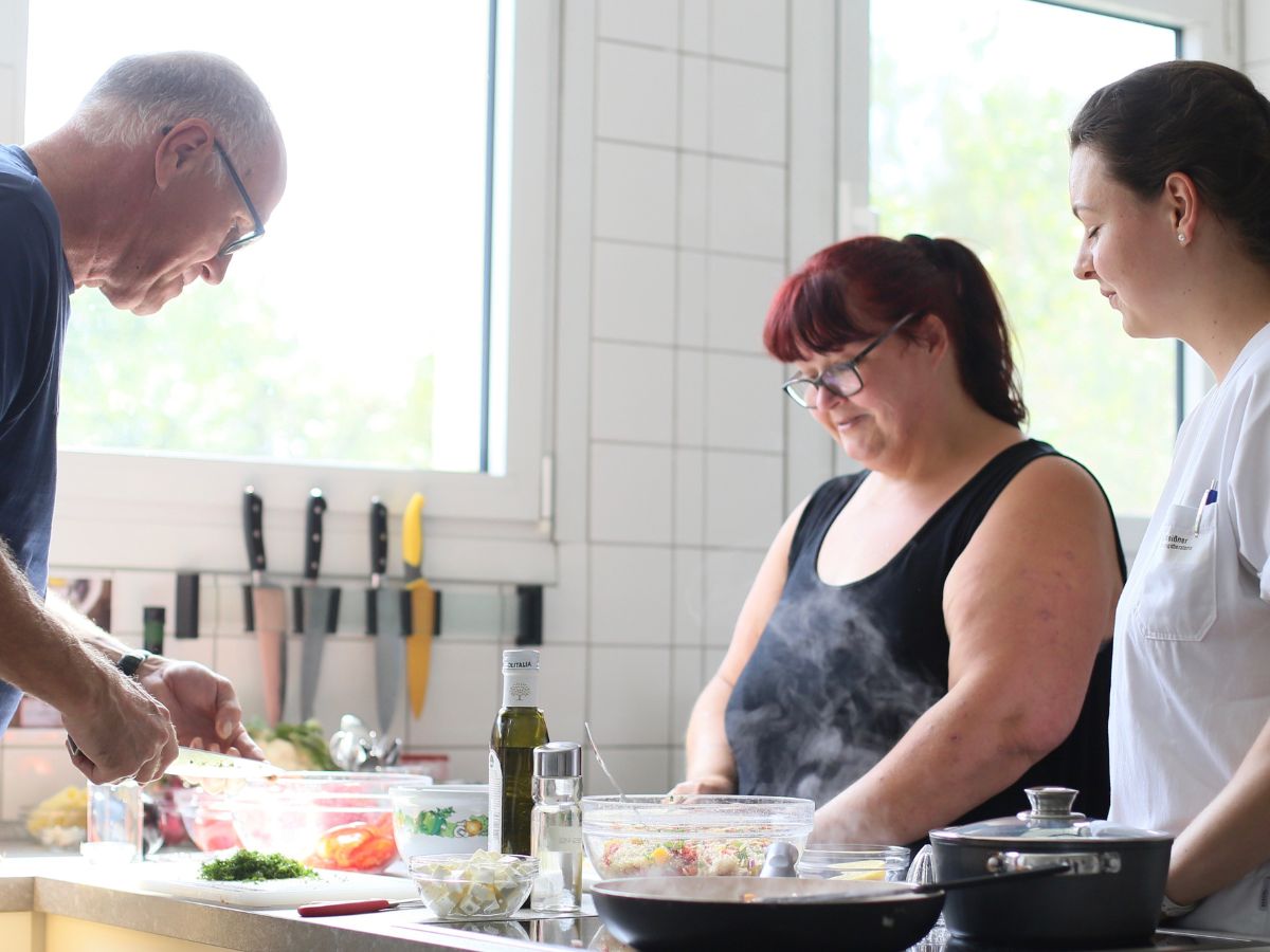 Die Personen bekommen etwas erklärt von dem Mann
