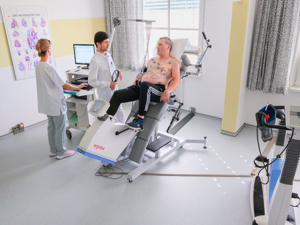 Eine Frau liegt auf einer Liege und zwei Pfleger sind um sie herum 