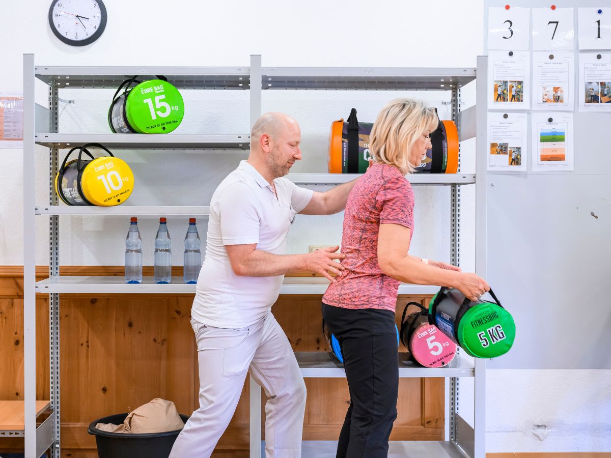 Der Pfleger hilft der Patientin bei der Übung 