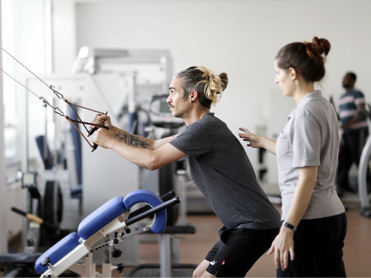 Eine Frau die einer Person hilft bei einer Übung 