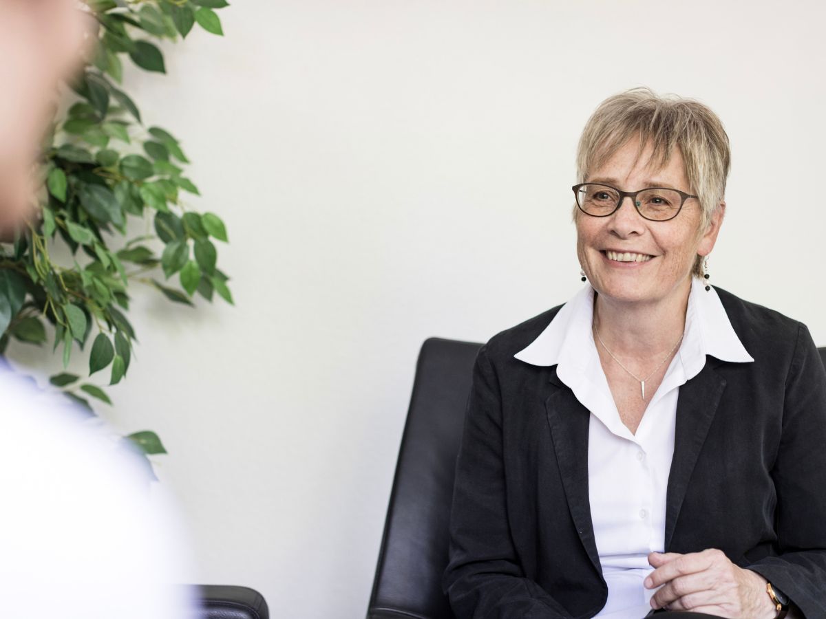 Eine Frau die sich mit der Person gegenüber unterhält 