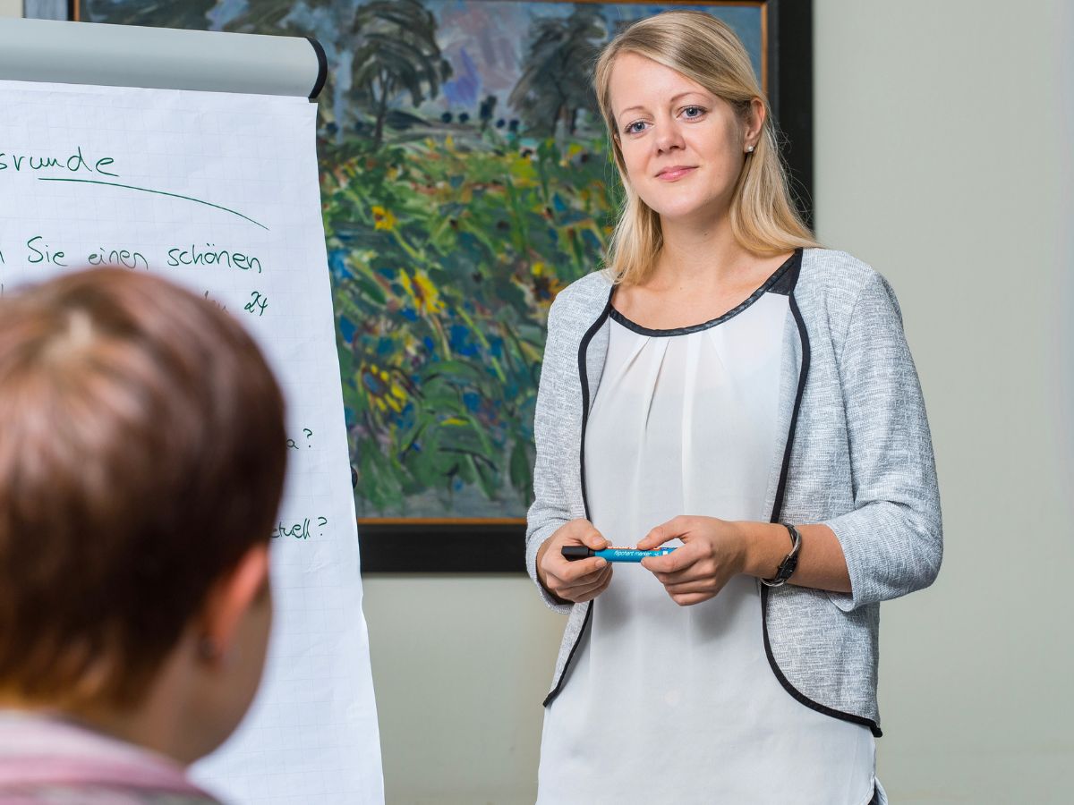Eine Frau die einer Person etwas erklärt 