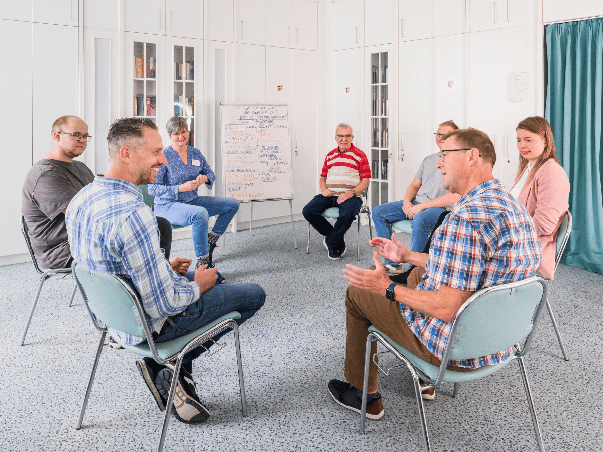 Eine Gruppe die sich unterhält und im Kreis sitzen 