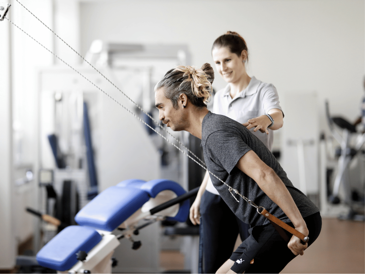 Eine Frau die einer Person hilft bei einer Übung 