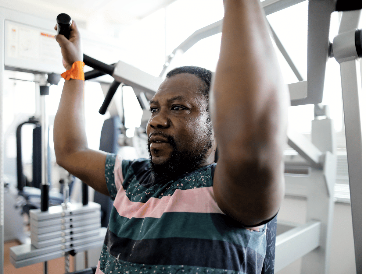 Ein Mann ist an einem Sportgerät und macht Übungen 