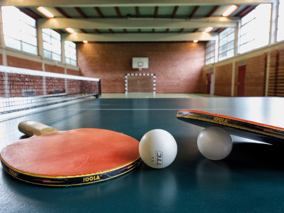 Zwei Tischtennisschläger liegen auf einer Tischtennisplatte