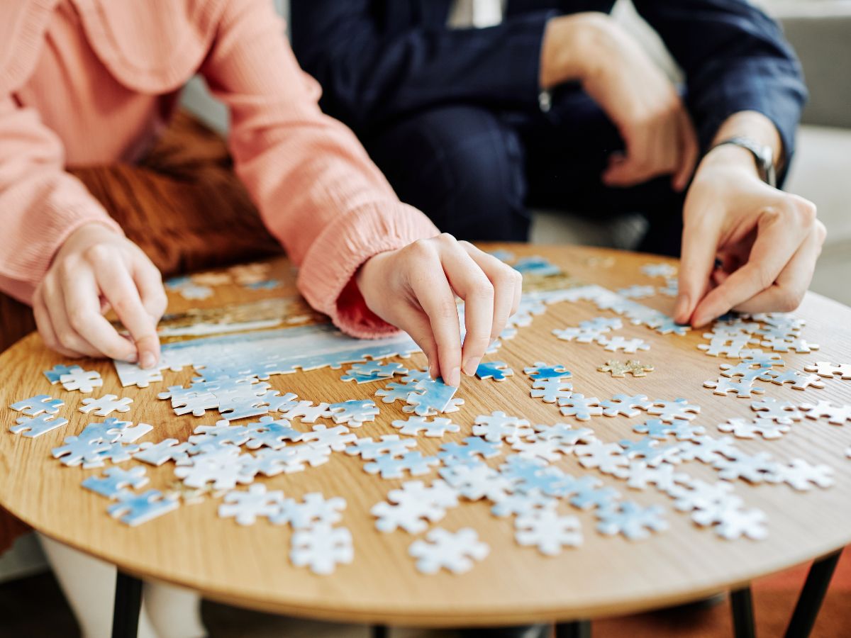 Die zwei Personen puzzeln 
