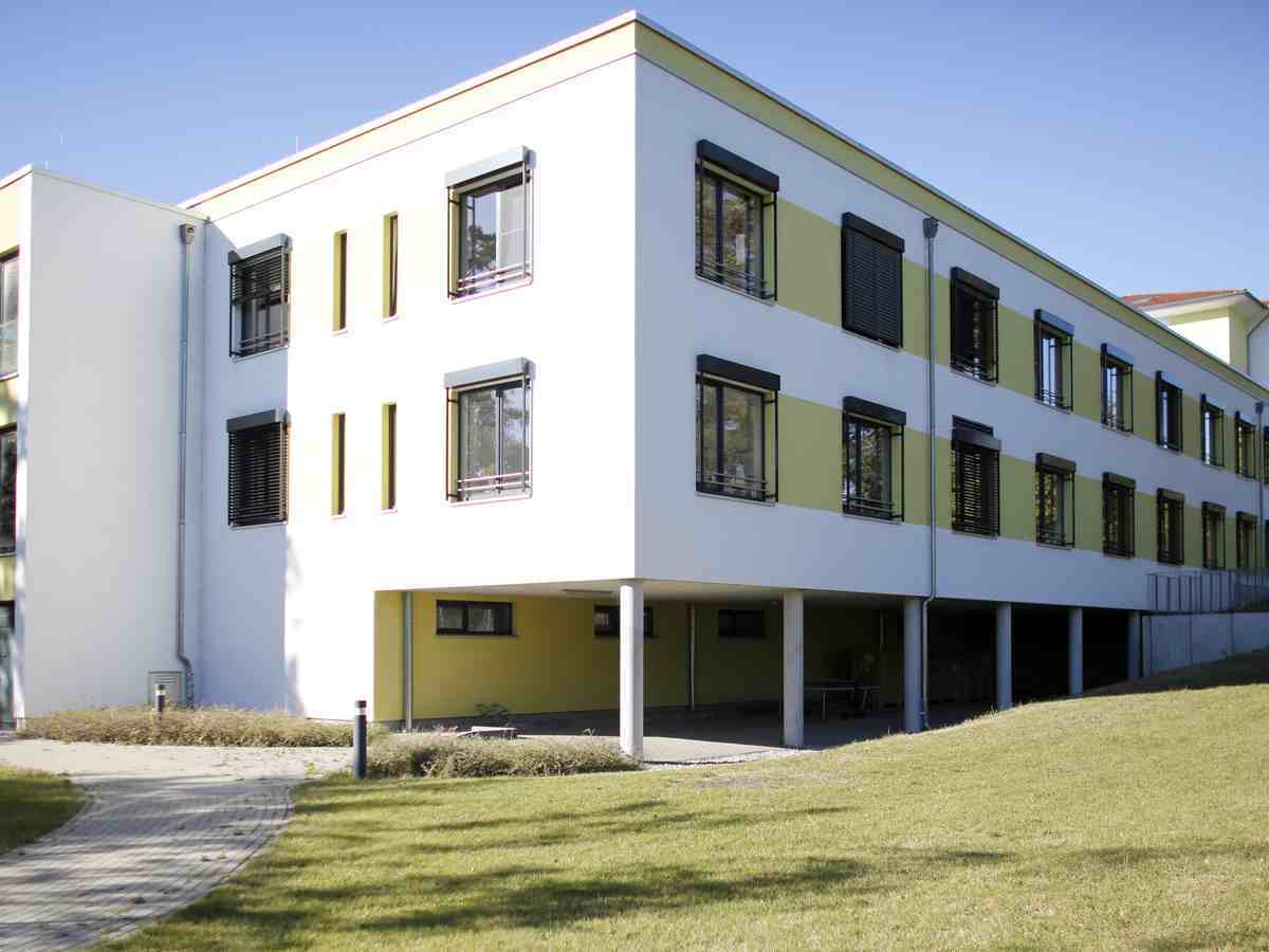 Außenansicht der MEDIAN Klinik Grünheide mit Grünflächen vor dem Gebäude.