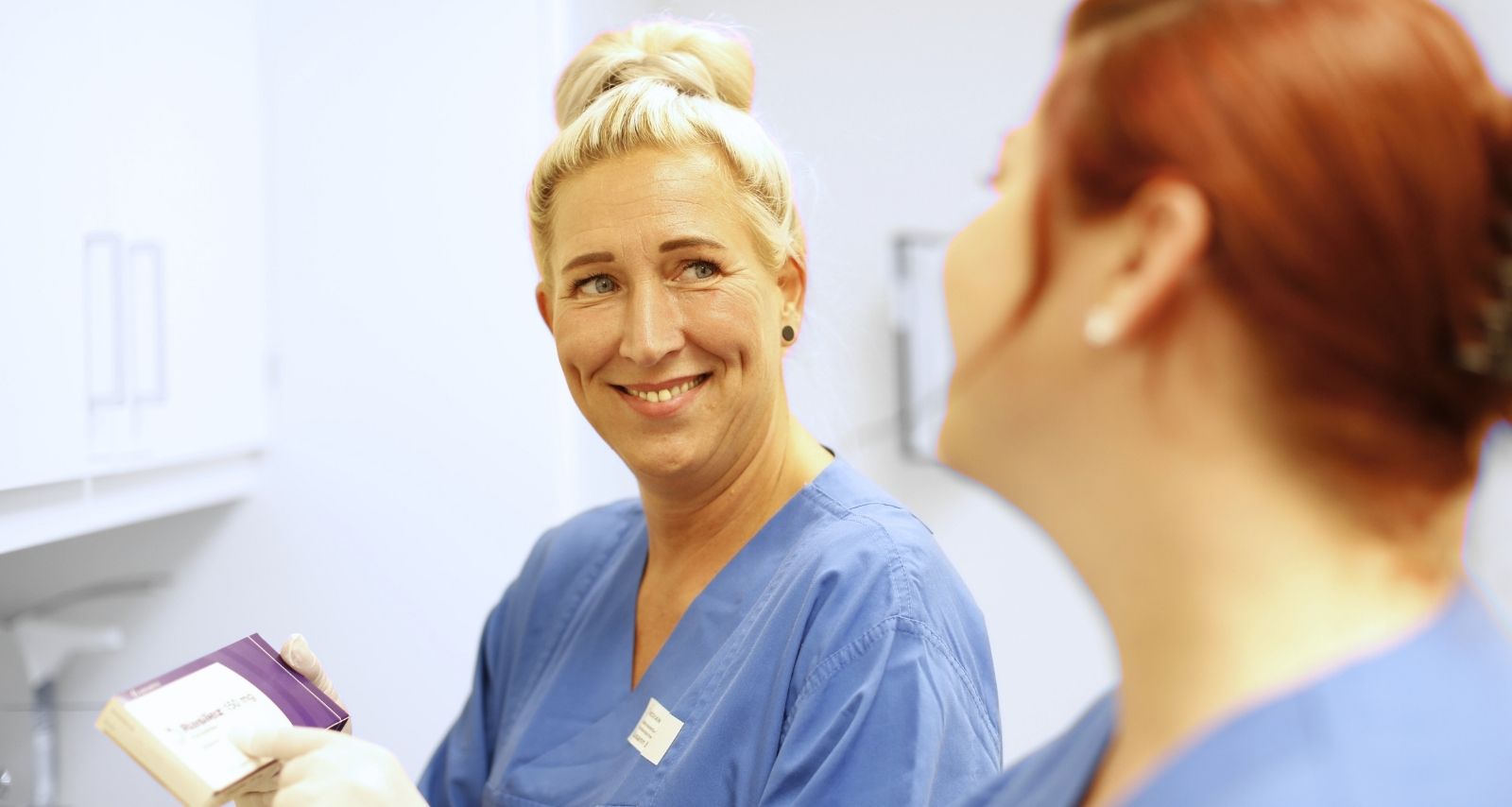 Zwei Pflegerinnen die sich anlächeln 