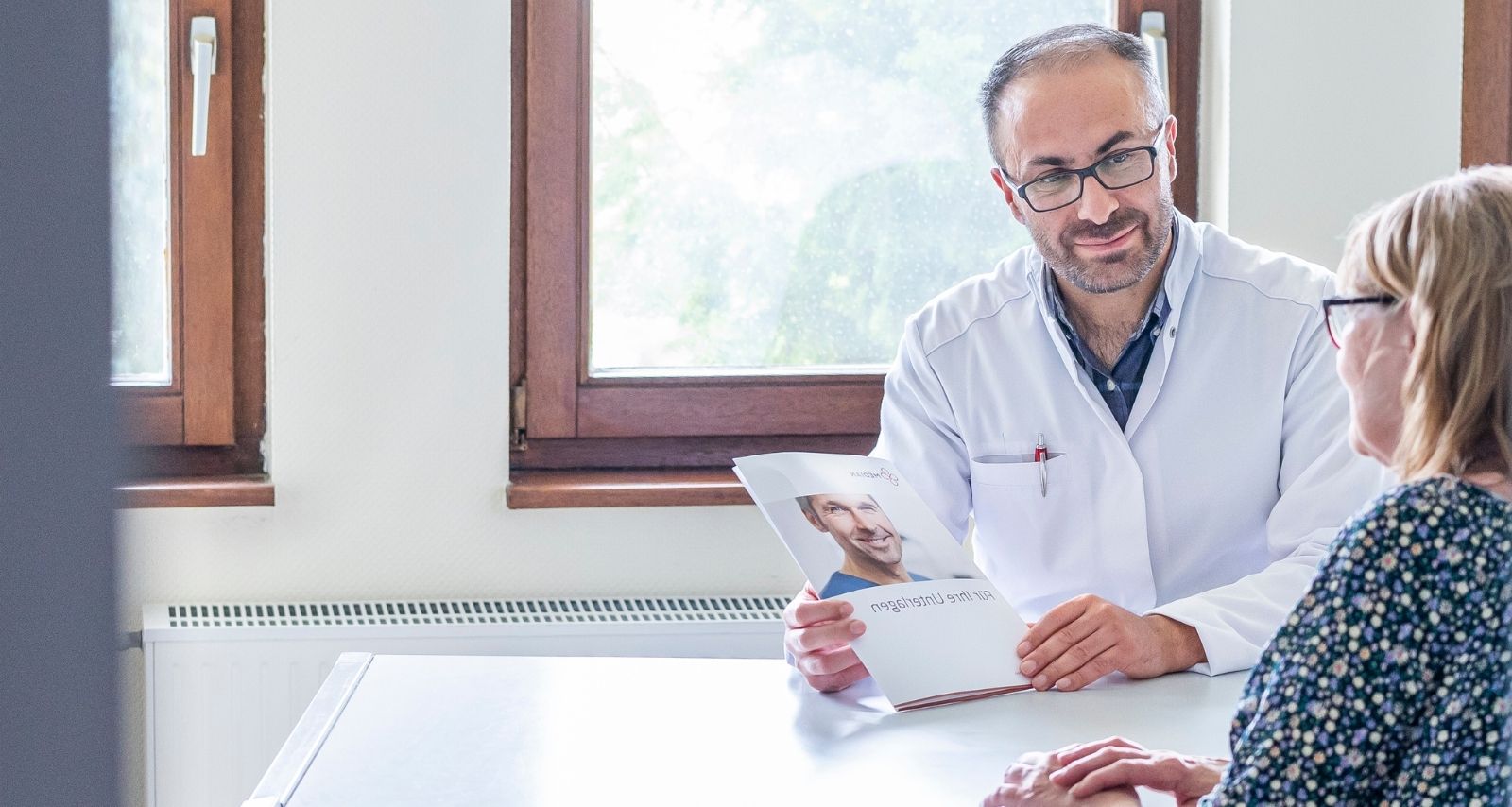 Ein Arzt der sich mit einer Patientin unterhält 