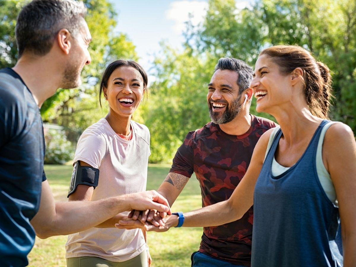 Vier Personen die, die miteinander Sport im Freien machen.
