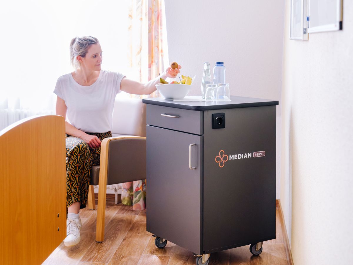 Patientin nutzt den Servicetrolley im Zimmer