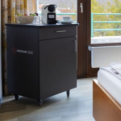 Servicetrolley mit Obstschale und Kaffeemaschine im Patientenzimmer.