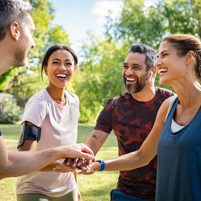 Vier Personen die, die miteinander Sport im Freien machen.