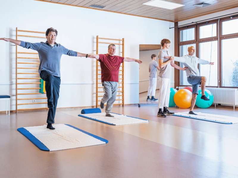 Eine Gruppe die auf Matten Sport machen 