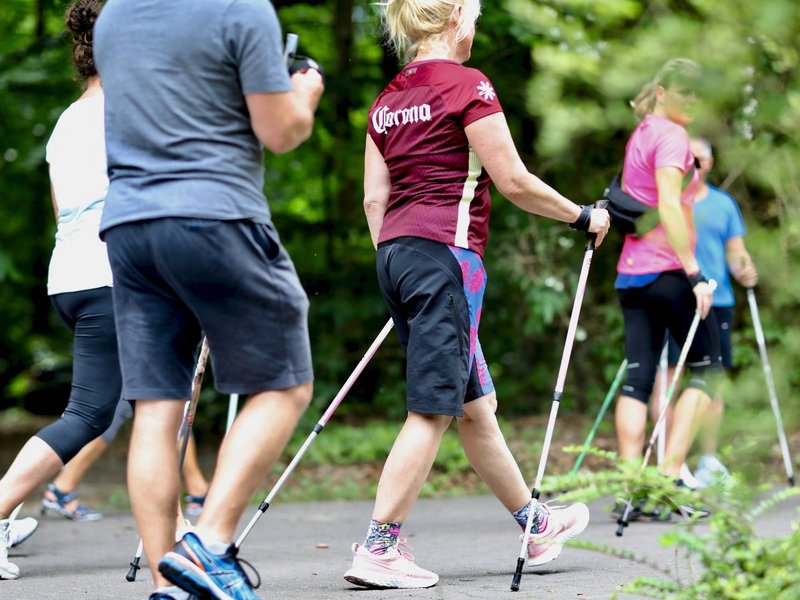 Eine Gruppe die mit Nordic-Walking-Stöcke läuft 