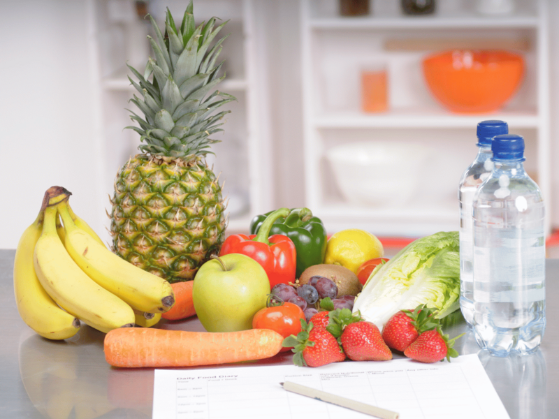 Auf einem Tisch liegt Obst, Gemüse und Wasser 