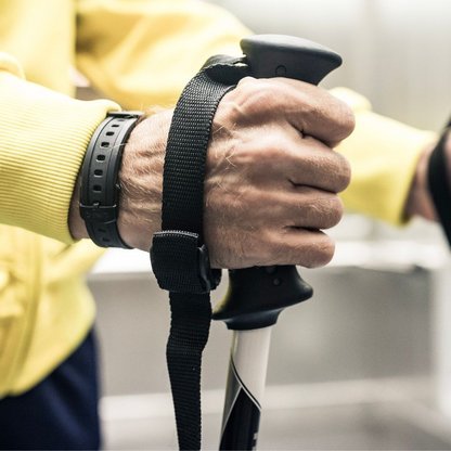 Eine Person mit Trekkingstöcke in der Hand 