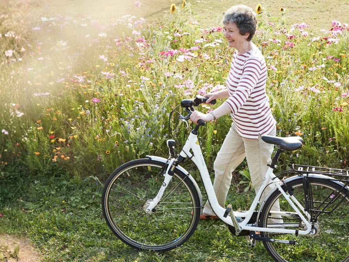 Eine Frau die ein Fahrrad schiebt 