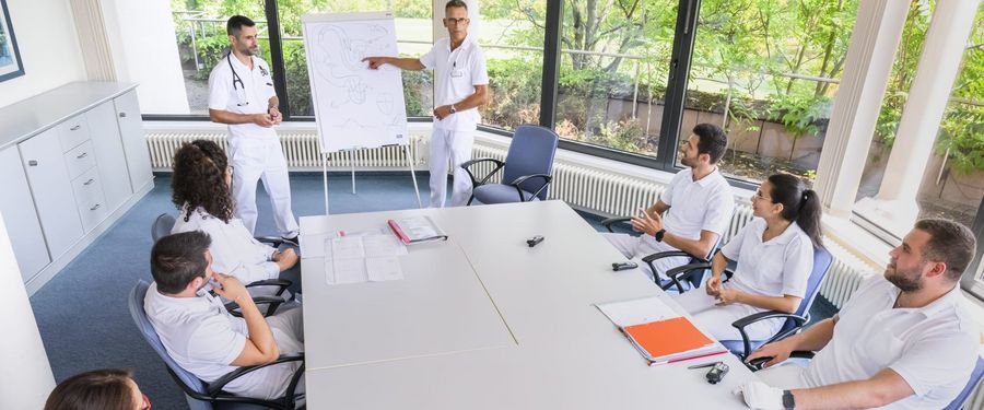 Ärzte, Therapeuten und Pflegekräfte besprechen einen Patientenfall Schmannewitz_23_591.jpg