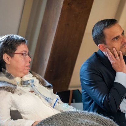 Zwei Personen die sitzen und zuhören 