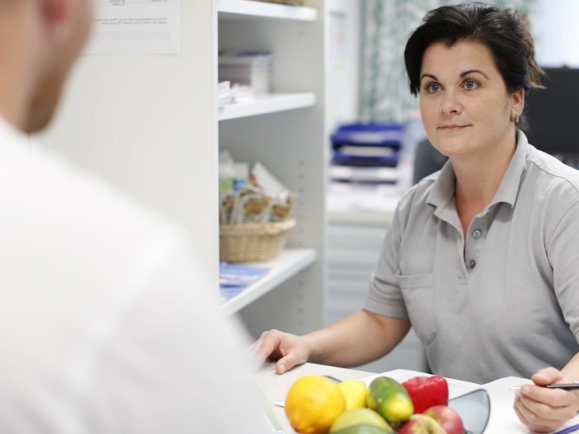 Eine Frau redet mit einer Person und vor ihr liegt Essen 